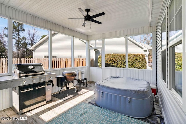 sunroom featuring a ceiling fan