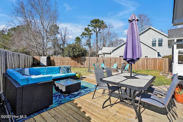 wooden deck with an outdoor hangout area, outdoor dining space, and a fenced backyard