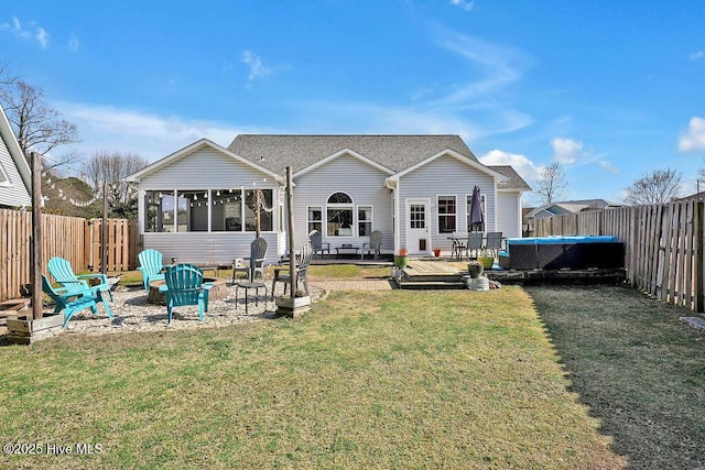 rear view of house with a yard, an outdoor fire pit, a fenced backyard, and a wooden deck