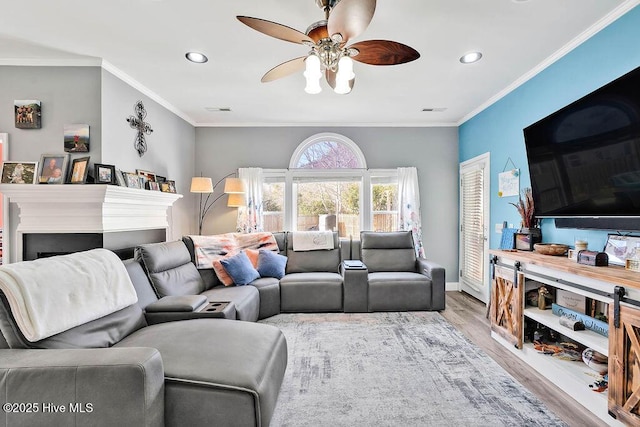 living room featuring ornamental molding, light wood-type flooring, a ceiling fan, and recessed lighting