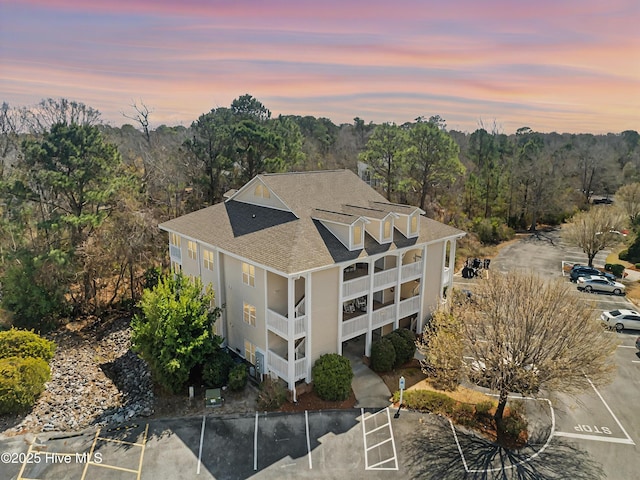 aerial view at dusk featuring a view of trees