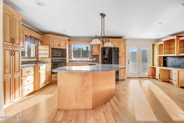 kitchen with a center island, light wood finished floors, black appliances, and open shelves