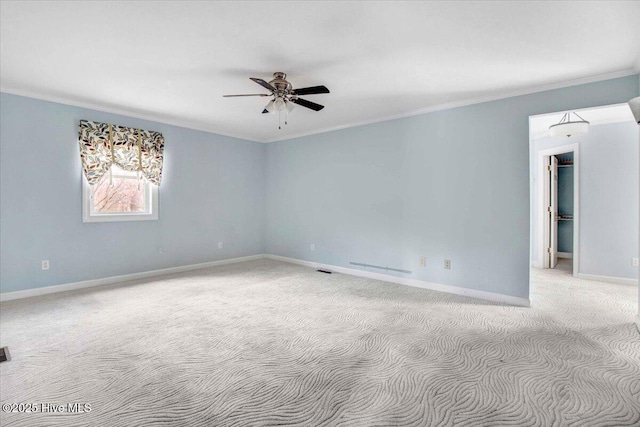 unfurnished room featuring light carpet, baseboards, visible vents, a ceiling fan, and crown molding