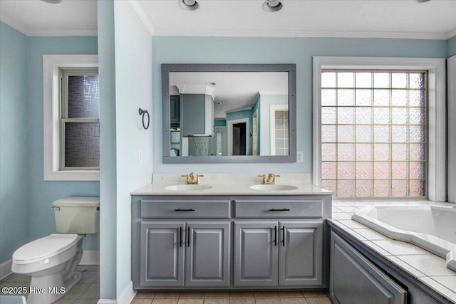 full bathroom with a garden tub, a sink, toilet, and crown molding