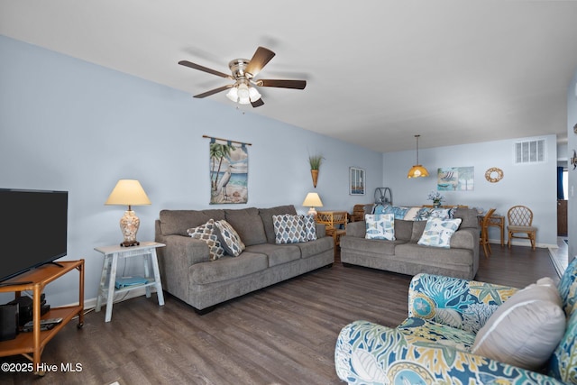 living area featuring visible vents, ceiling fan, baseboards, and wood finished floors