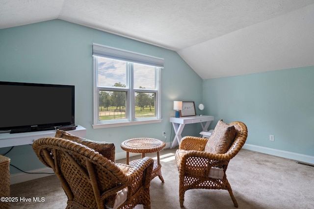 living area featuring baseboards, lofted ceiling, visible vents, and carpet flooring