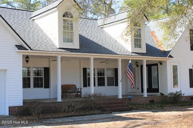 cape cod-style house with roof with shingles, covered porch, and ceiling fan