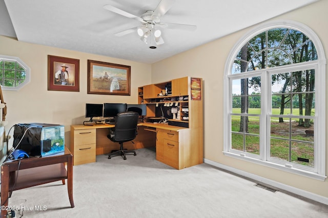 office featuring ceiling fan, baseboards, visible vents, and light carpet