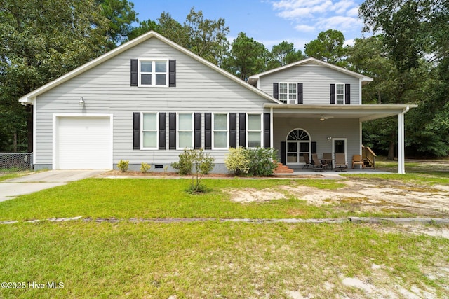 traditional-style house featuring a front yard, concrete driveway, an attached garage, and ceiling fan