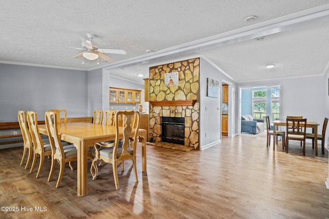 dining room featuring a textured ceiling, crown molding, ceiling fan, and wood finished floors