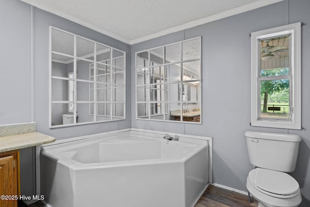 full bathroom featuring ornamental molding, toilet, a bath, and a textured ceiling