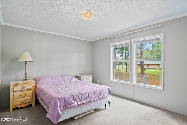 carpeted bedroom with a textured ceiling and crown molding