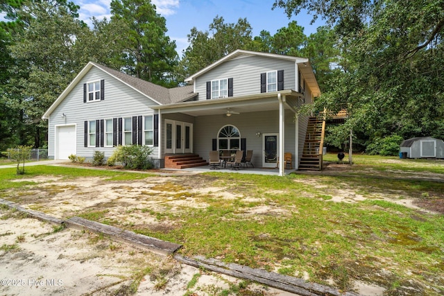 back of house featuring stairs, french doors, a garage, an outbuilding, and a storage unit