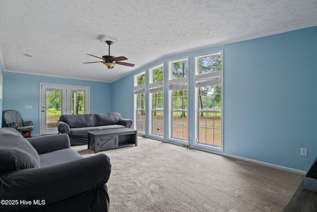 living area featuring crown molding, baseboards, ceiling fan, vaulted ceiling, and carpet flooring