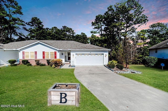 ranch-style house with a garage, a yard, brick siding, and concrete driveway