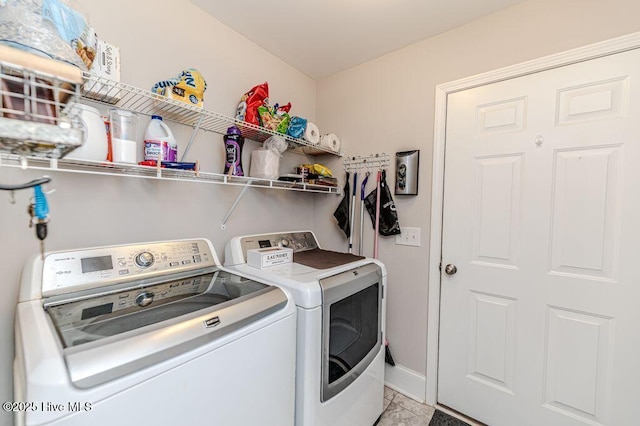 laundry area featuring laundry area, baseboards, and washer and clothes dryer