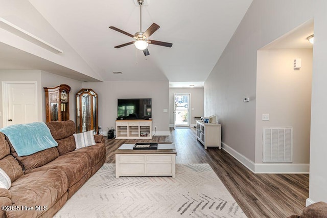 living room with dark wood-style floors, visible vents, a ceiling fan, vaulted ceiling, and baseboards