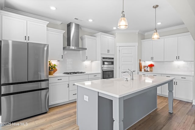 kitchen with visible vents, ornamental molding, stainless steel appliances, light countertops, and wall chimney range hood