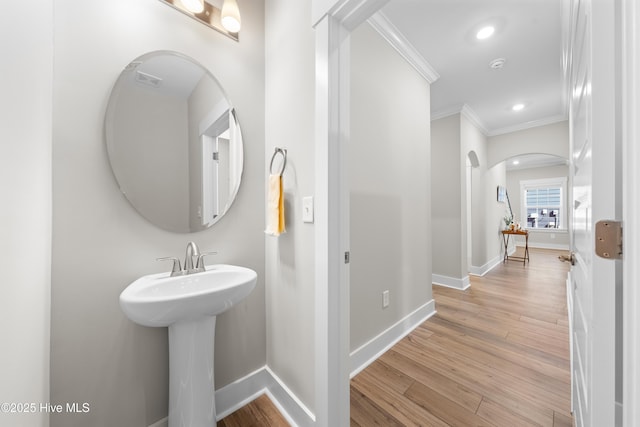 bathroom with crown molding, baseboards, wood finished floors, and recessed lighting