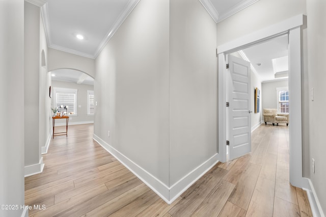 hall with baseboards, arched walkways, crown molding, light wood-type flooring, and recessed lighting