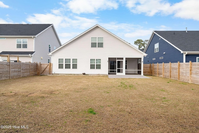 rear view of house featuring a sunroom, a fenced backyard, and a yard