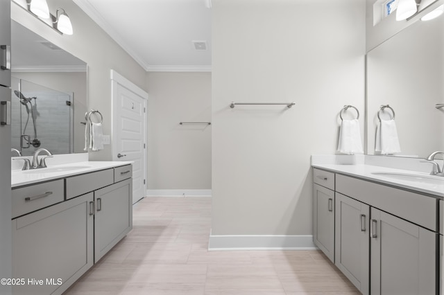 full bath featuring crown molding, a sink, a shower stall, and baseboards