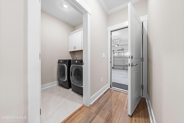 laundry room with ornamental molding, cabinet space, baseboards, and separate washer and dryer