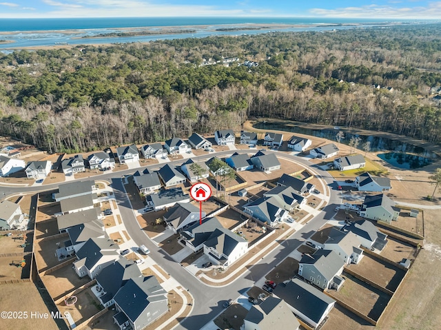 birds eye view of property featuring a residential view, a water view, and a forest view