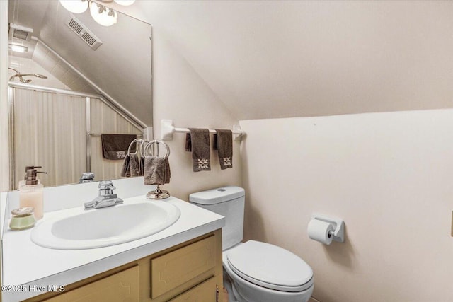 bathroom with lofted ceiling, visible vents, vanity, and toilet