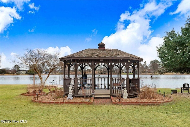 dock area featuring a water view, a lawn, and a gazebo