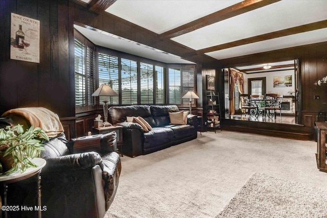 living room featuring carpet floors, wooden walls, and beam ceiling