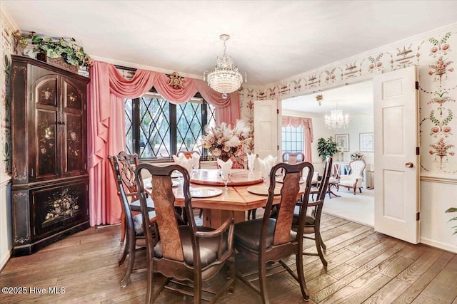 dining area with light wood-style floors, wallpapered walls, a chandelier, and crown molding