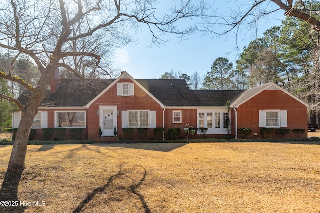 cape cod-style house featuring brick siding, crawl space, and a front lawn