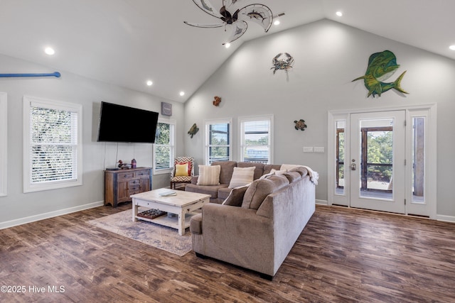 living room with high vaulted ceiling, baseboards, and wood finished floors