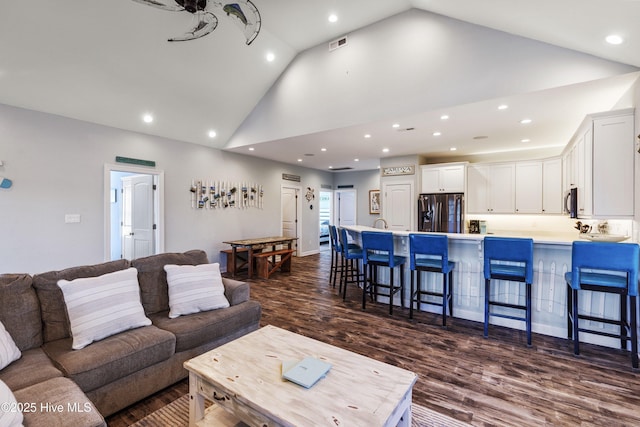 living room featuring high vaulted ceiling, recessed lighting, visible vents, and dark wood finished floors