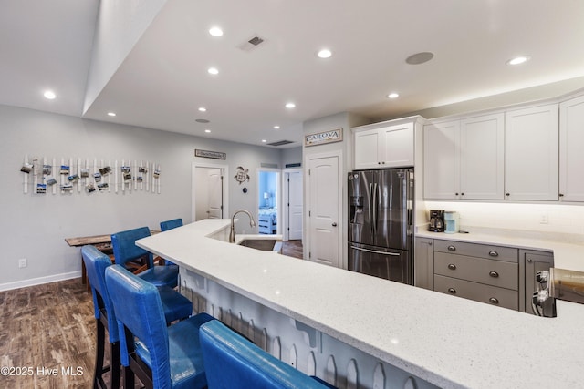 kitchen with visible vents, white cabinets, dark wood-style flooring, stainless steel refrigerator with ice dispenser, and recessed lighting