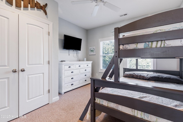 bedroom with light carpet, visible vents, and a ceiling fan