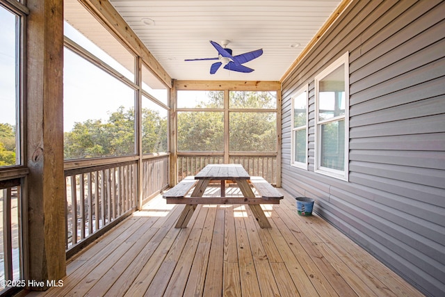 unfurnished sunroom with ceiling fan