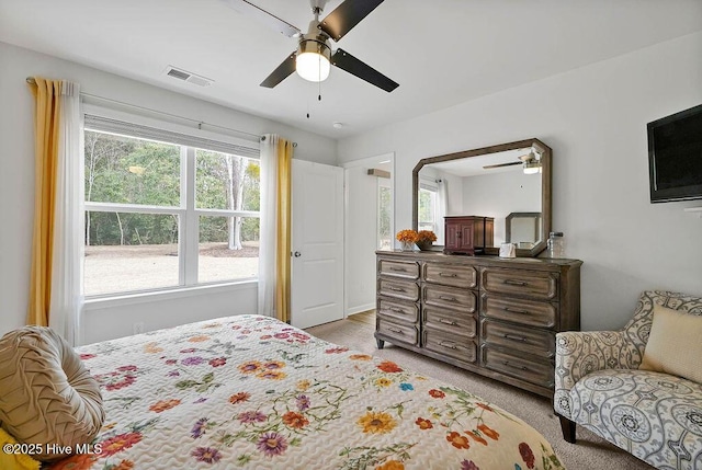 bedroom featuring light colored carpet, visible vents, and ceiling fan