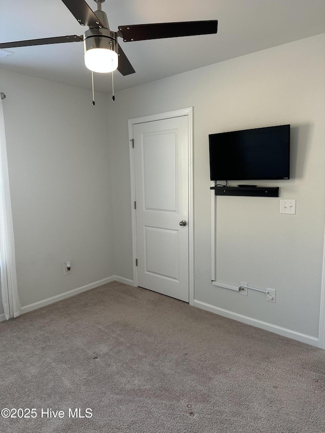 unfurnished bedroom featuring carpet flooring, a ceiling fan, and baseboards