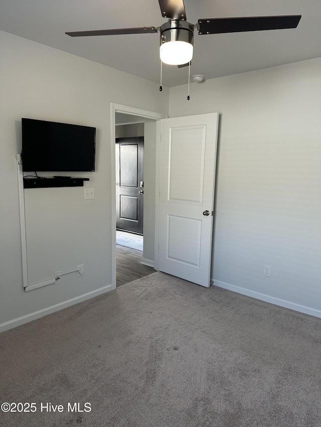 unfurnished room with carpet floors, baseboards, and a ceiling fan