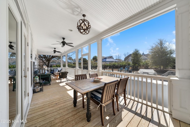 wooden terrace with outdoor dining area and ceiling fan