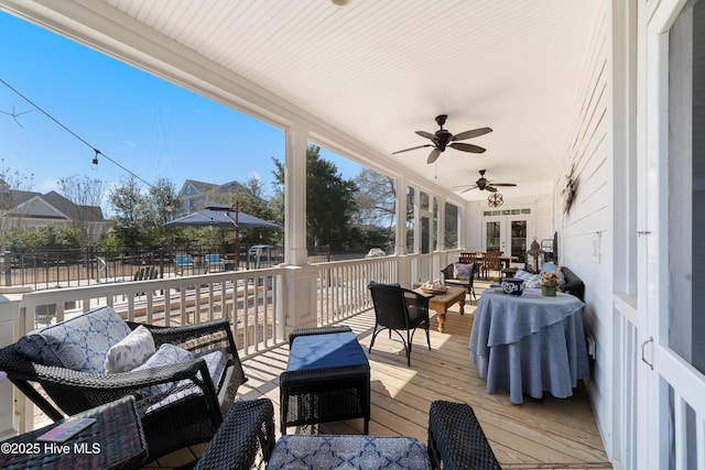 wooden terrace with an outdoor living space, french doors, ceiling fan, and fence