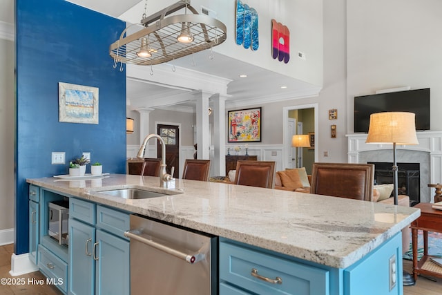 kitchen with crown molding, open floor plan, stainless steel appliances, blue cabinets, and a sink