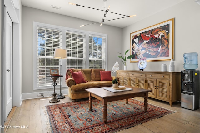 living area featuring visible vents, baseboards, and light wood-style floors