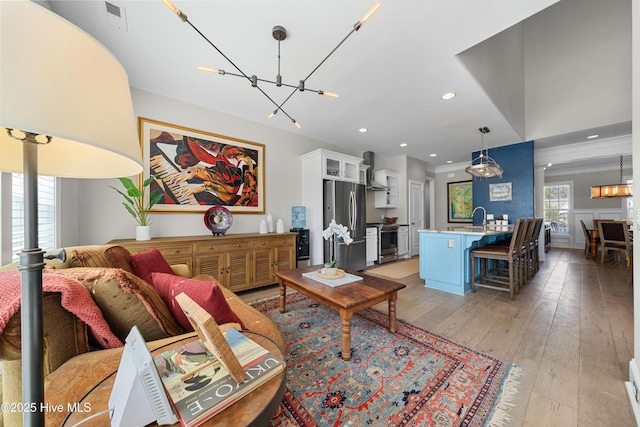 living area featuring recessed lighting, visible vents, light wood-style floors, and a chandelier