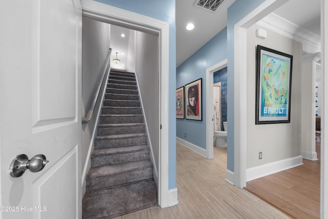 staircase featuring recessed lighting, visible vents, baseboards, and wood finished floors