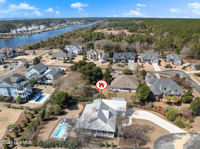 drone / aerial view featuring a forest view, a water view, and a residential view