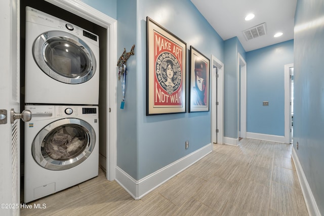 clothes washing area with recessed lighting, visible vents, stacked washer and clothes dryer, and baseboards