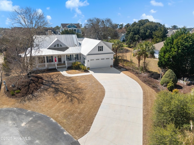 view of front of house with a porch, concrete driveway, an attached garage, and metal roof